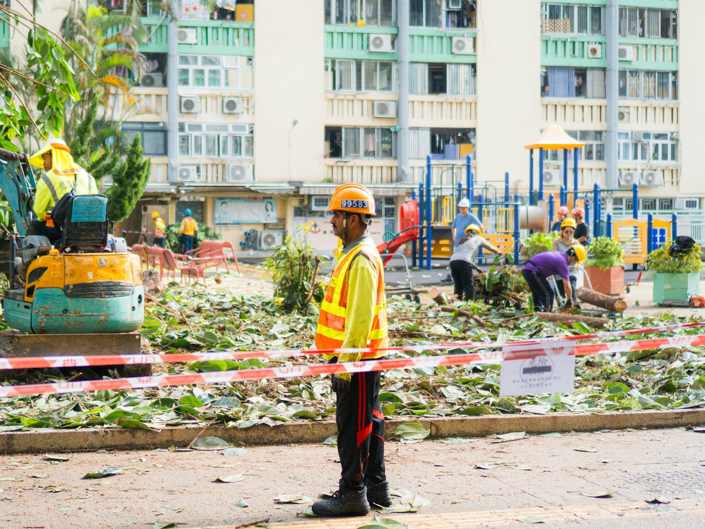Construction workers clearing debris from an urban residential area.